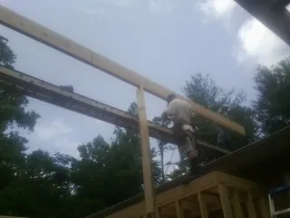 Carpenter setting a ridge beam over a new addition frame — Ice Dam Removal by Roofing Brothers in Franklinton