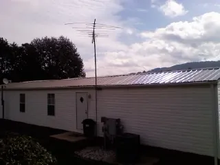 New metal roof on a single wide mobile home with a TV antenna in Franklinton