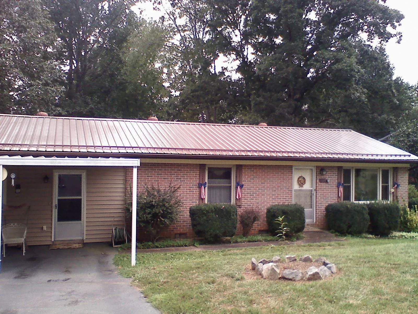 Bronze metal roof and carport on a brick ranch home — Roof Repair work by our crew in Franklinton