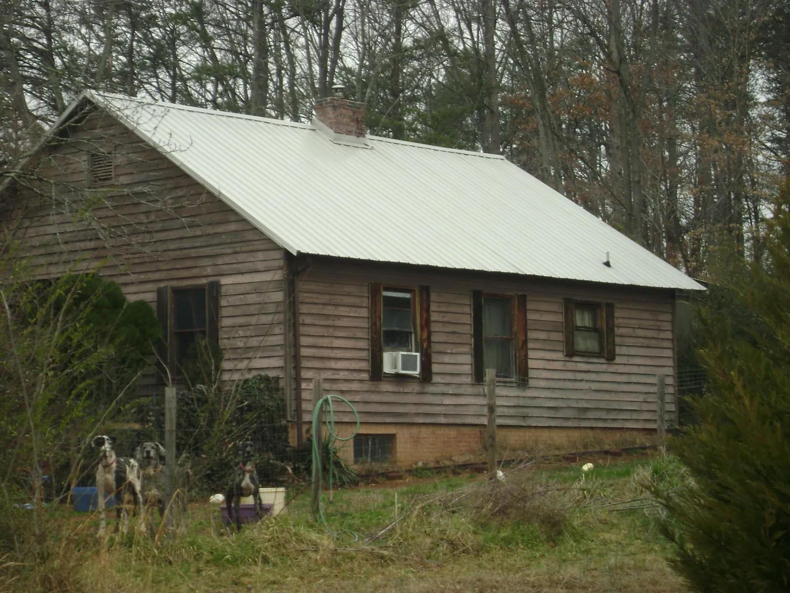 White metal roof on an old wood sided farmhouse, from a Metal Roof Installation job in Franklinton